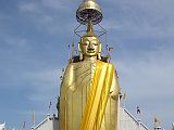 Bangkok 02 01 Luang Pho To Buddha Statue We met a nice man on the way to the Grand Palace, who told us it was closed this morning. Although I had read of this scam, I was feeling great and compassionate and wanted to see how it played out. He mentioned that he could get us a private tuk-tuk tour to show us around some of the Bangkok sights for only a hundred Baht. We took him up on his offer. As long as you are willing to say no to the shopping portion of the tour, its great fun indeed. Our first stop was at Luang Pho To, a gigantic 32m x 11m statue of Buddha, built starting in 1867, and covered in 24k golden mosaics. The topknot of the Buddha image supposedly contains a relic of Lord Buddha brought from Sri Lanka.